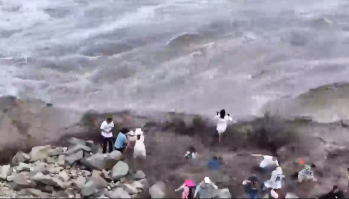 Çin’den korkutan görüntüler! Dalgalar insanları kayalıkların arasından sürükledi